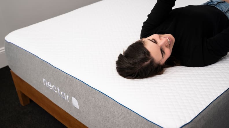 a woman lies on her back on the Nectar mattress