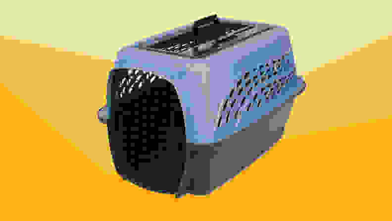 A blue and black pet carrier against a varied yellow background.