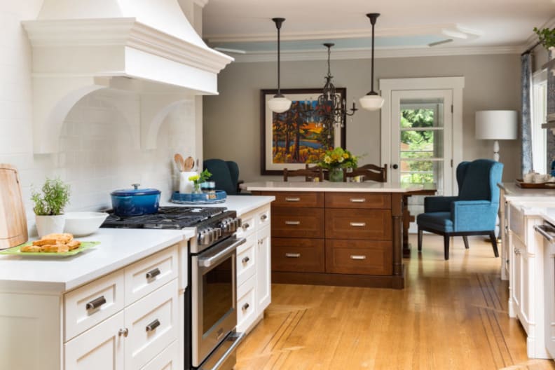 This white kitchen has colorful accents and a millwork range hood