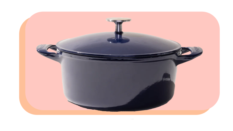 A blue Made In Dutch oven against a pink background.
