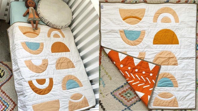 A quilt with rainbows on a children's bed.