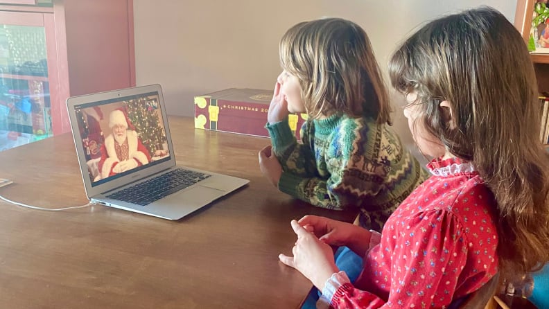 A boy and a girl watching Santa on a laptop