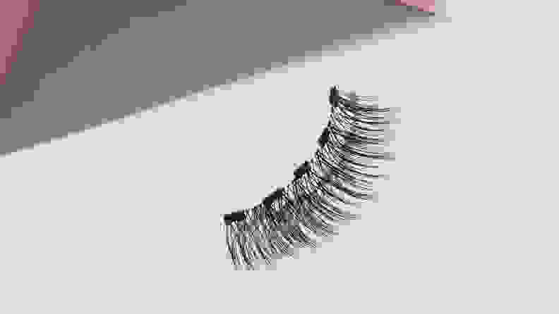 A single magnetic eyelash from the Lola’s Lashes Rose Quartz Magnetic Eyelashes and Eyeliner Kit on a white background.