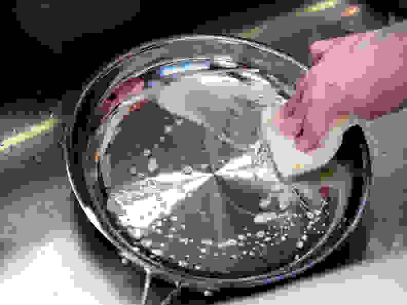 cleaning stainless steel pan with sponge