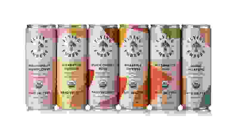 An assortment of colorful cans of hard seltzers on a white background.