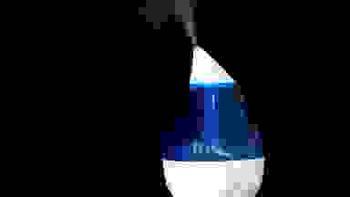A white and blue humidifier on a black background