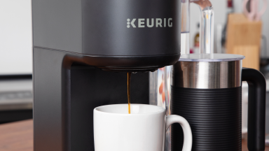 Close-up of a Keurig coffee machine brewing coffee into a white mug