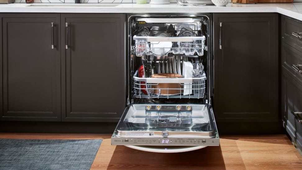 The LG dishwasher, installed in a modern kitchen setting, completely loaded up with dishes.