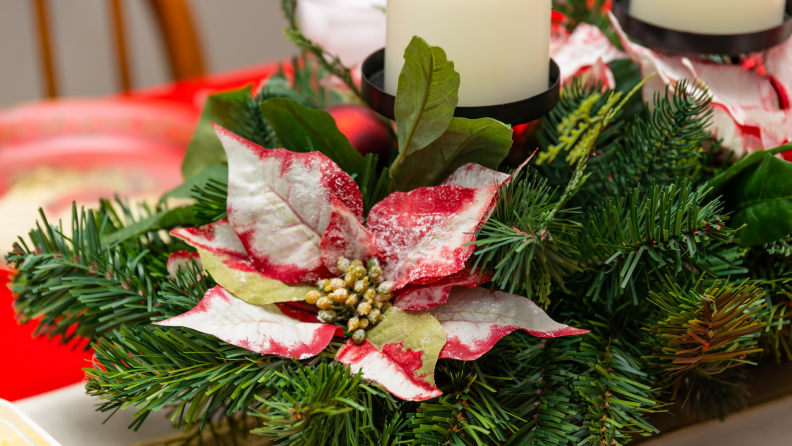 Evergreen centerpiece with faux red flowers and candles