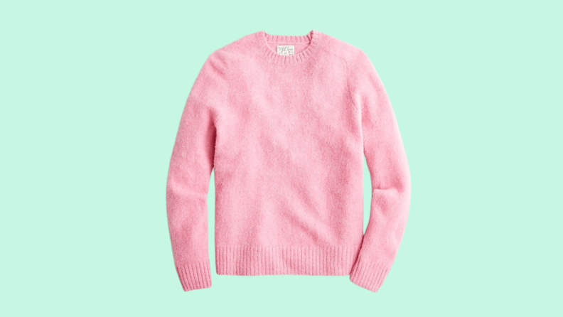 A pink sweater against a green background.