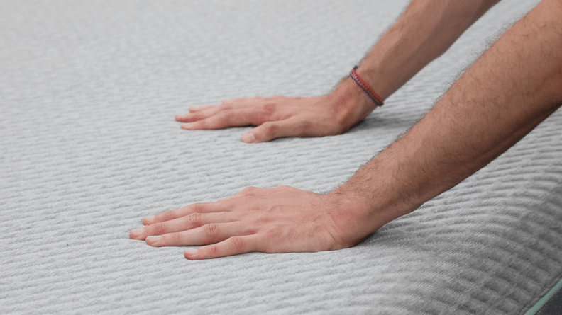 A gif of a pair of hands pressing down on the mattress.