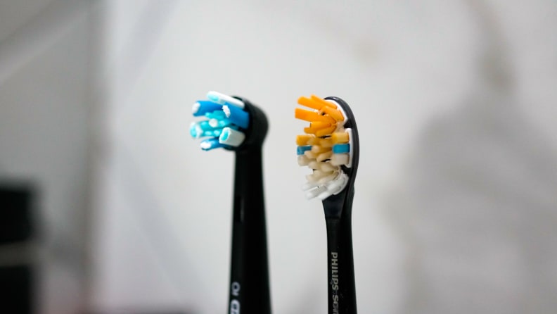 The brush heads of an Oral B and Philips Sonicare electric toothbrush placed side-by-side, in order to compare the differences between them.