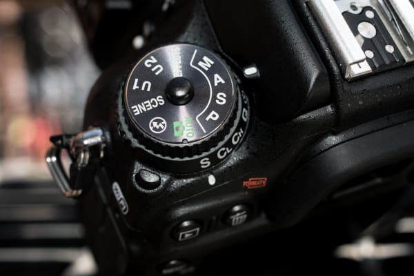 The mode dial and drive mode dial are stacked on the top left of the camera.