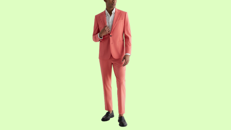 A model wearing a bright salmon suit.