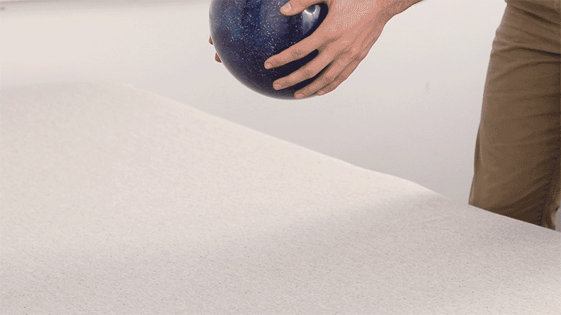 A GIF showing off a bowling ball being dropped into the mattress and then being absorbed by it.