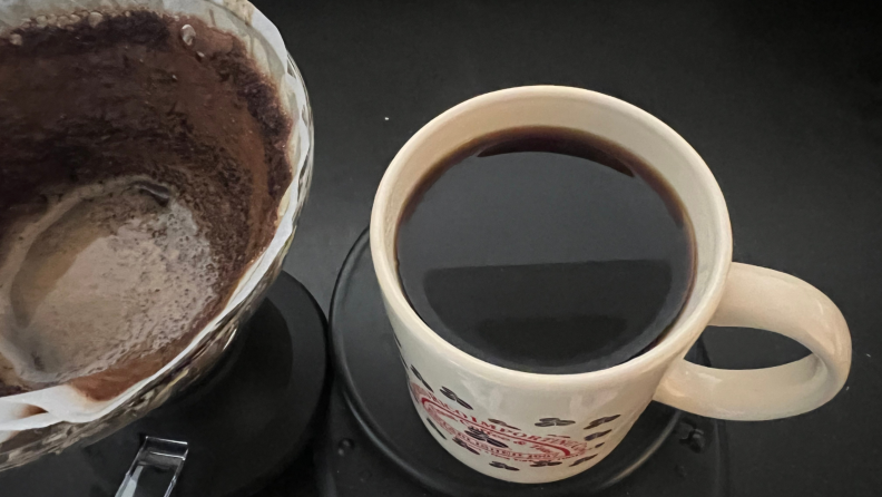 Used Hario Switch filter with coffee grounds next to cup of coffee