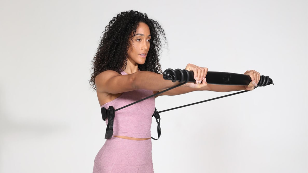 A woman using the Bodygym trainer to perform chest presses.