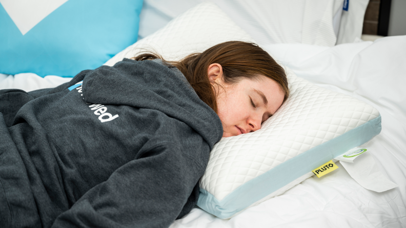 A woman sleeping with a Pluto Pillow.