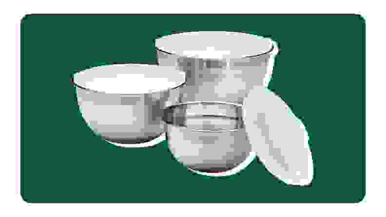 Three stainless steel mixing bowls on a green background