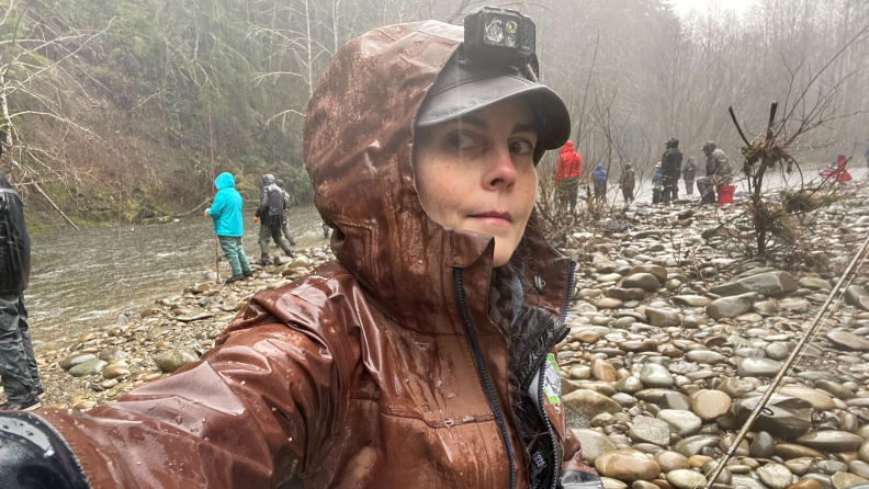 A woman taking a selfie, in the rain with Simms fishing clothes on.