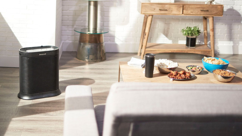 A Honeywell air purifier sits on the floor of a living room.