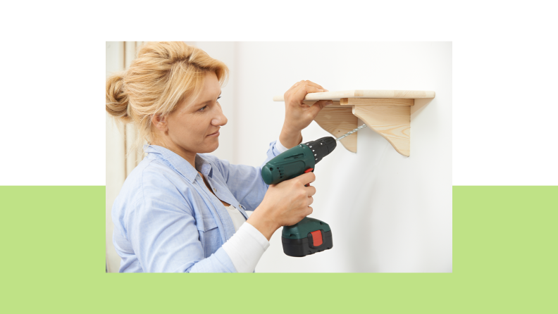 Person using cordless drill to mount shelf on wall.