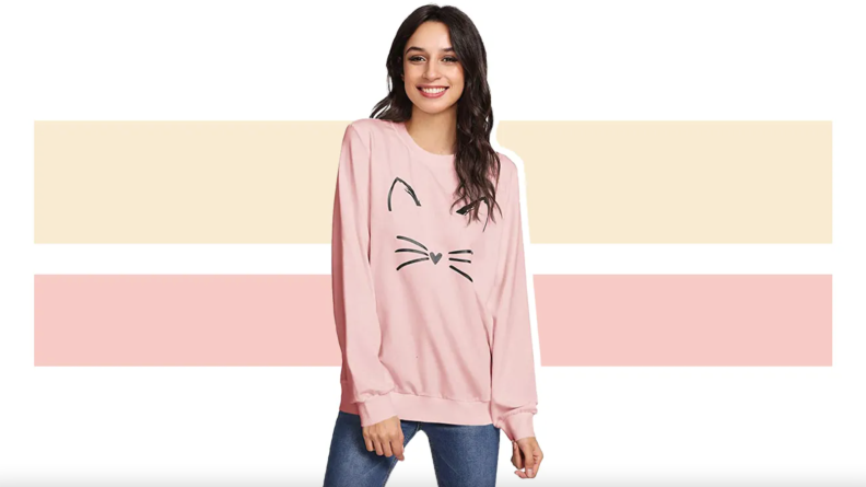Person wearing pink pullover with cat design