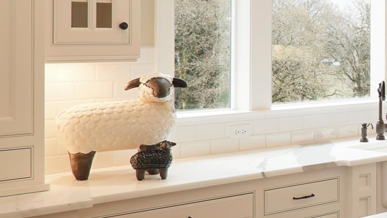 A decorative ceramic lamb sitting in a kitchen countertop.