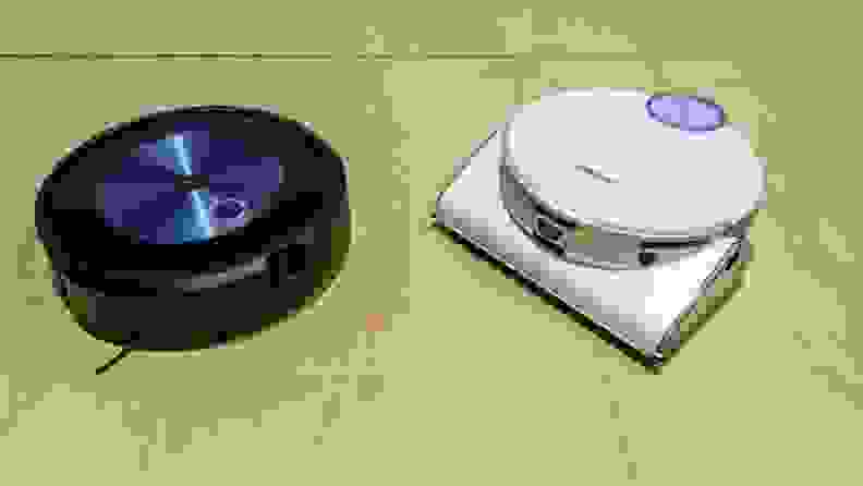 iRobot and a Samsung robot vacuum sit on a yellow table surface