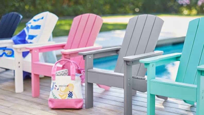 a row of four multi-colored child's Adirondack chairs