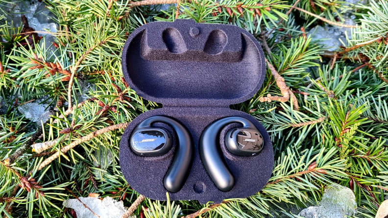 Bose Sport Open Earbuds buds in case on a bed of pine