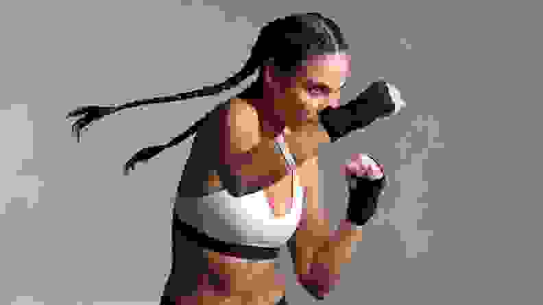A woman shadow boxing and throwing a punch.