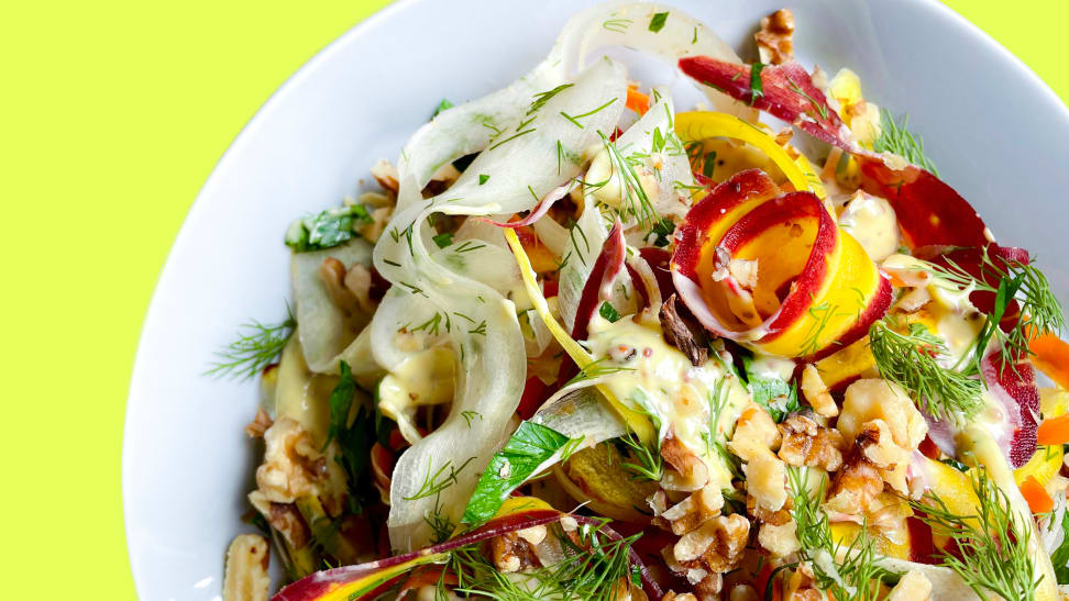 A bowl filled with carrot, herb, and dijonnaise salad.