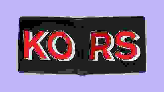 Black wallet with red text that says 'Kors' against a purple background
