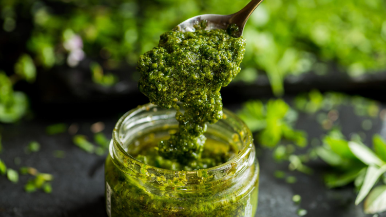 Spooning pesto out of a jar