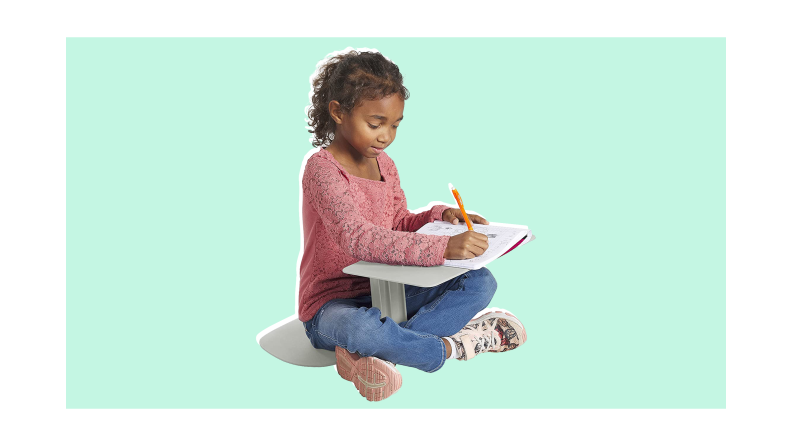 Child using the ECR4Kids The Surf Portable Lap Desk to write in workbook.