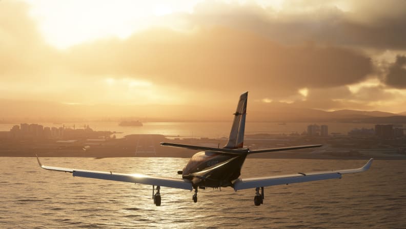 A screenshot of a plane flying above a sea at sunset.