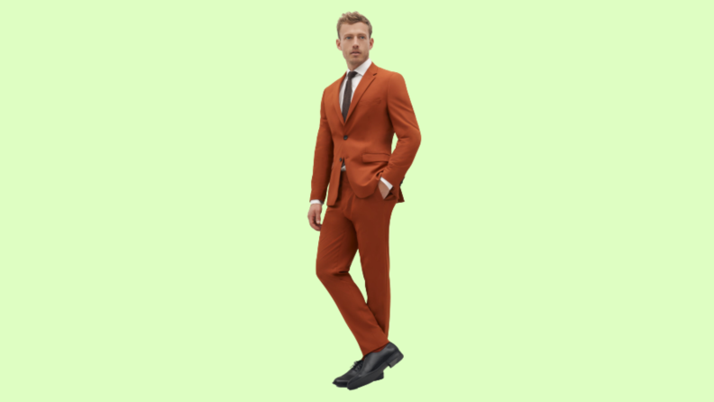 A model wearing a burnt orange suit.