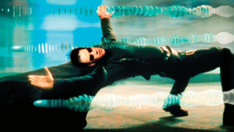 Neo, played by Keanu Reeves in The Matrix, dodges gunfire in slow motion.