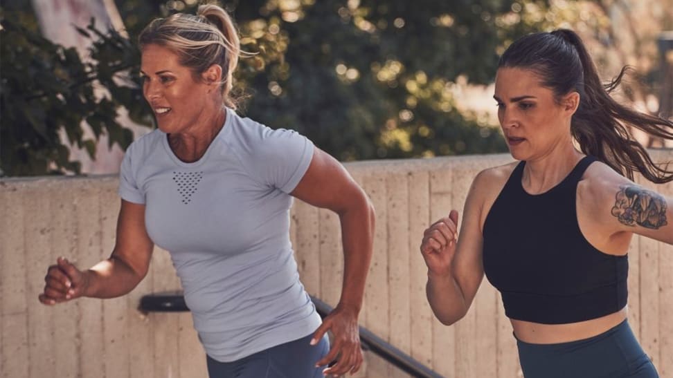 Two women running up stairs as part of a workout.