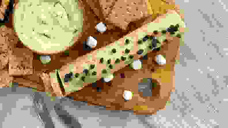 A sliced log of flavored butter on a board