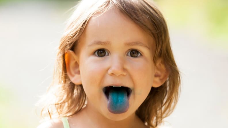 A young child with a bright blue tongue