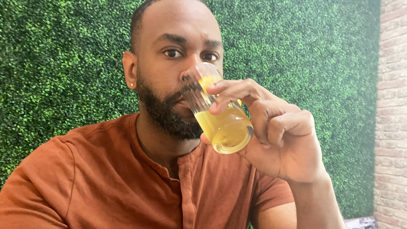 A tester drinks a glass of green tea