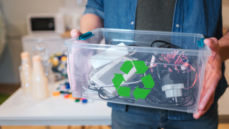 Person holding a box of electronics to be recycled.