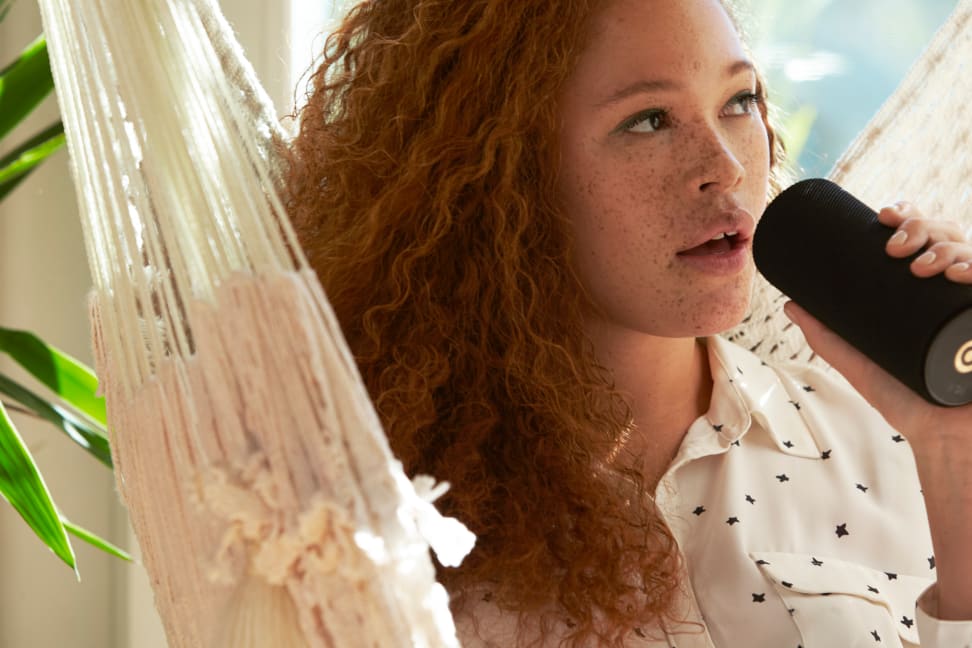 A woman speaks into the Amazon Tap