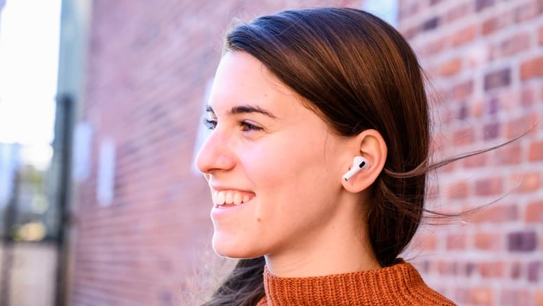 A person wears wireless headphones outside.
