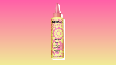 Amika frizz-fighting hair treatment against a pink and yellow background.