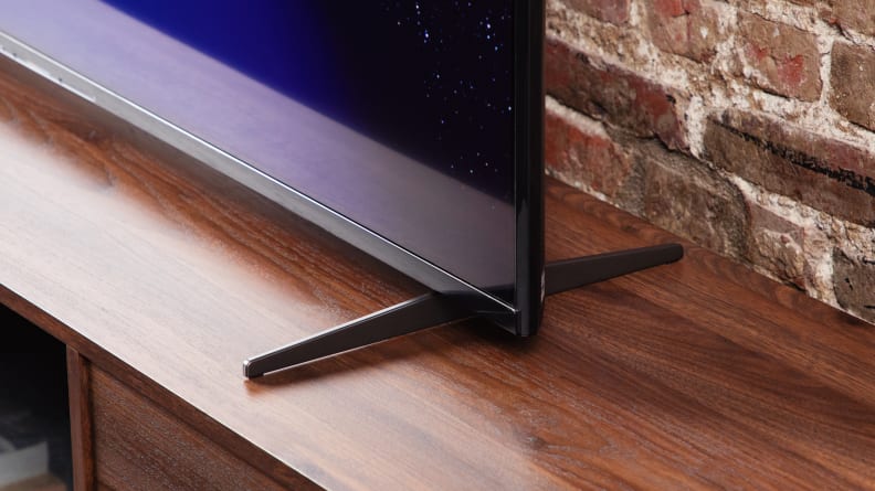 A black and blue corner of the Sony X90K LED TV screen and the legs of the stand.