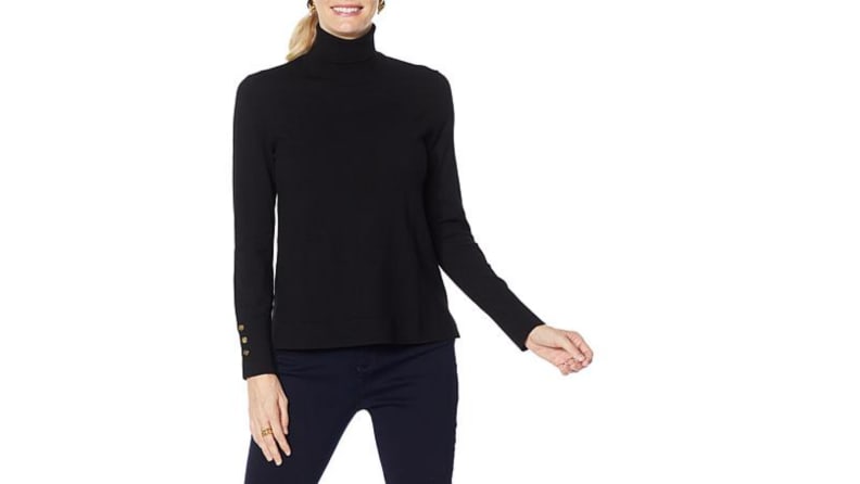 An image of a black turtleneck with gold button details on the sleeves.