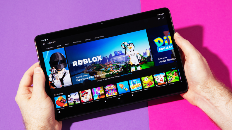 A pair of hands holds the Amazon Fire 11 Max tablet in landscape mode
